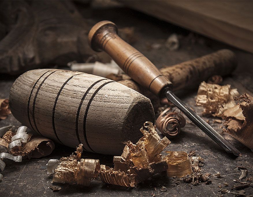 Holzhammer und Meißel umgeben von Holzspänen